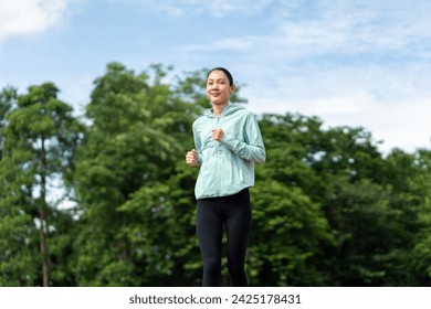 Happy asian slim woman wearing sportswear jogging on track at sport stadium. Young beautiful asian female in sports bra running outdoor. Workout exercise in the morning. Healthy and active lifestyle - Powered by Shutterstock