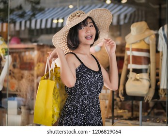 Happy Asian Teenager Holding Yellow Bag At Shopping Mall, Lifestyle Concept.