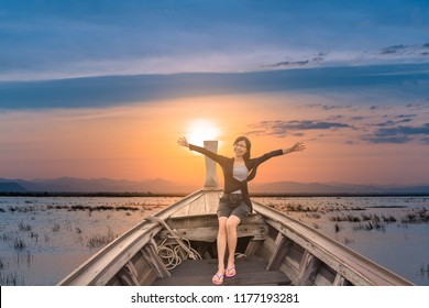 Happy Asian Tourist Girl 45 Years Old Relaxing On Boat Her Arms Open Feeling Freedom Sea And Blue Sky As Background.