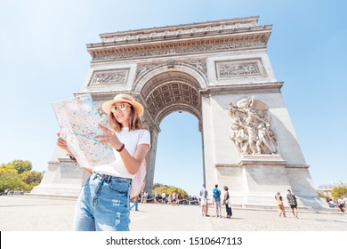 Happy Asian tourist girl enjoys the view of the majestic and famous Arc de Triomphe or Triumphal arch. Solo Travel and voyage to Paris and France - Powered by Shutterstock