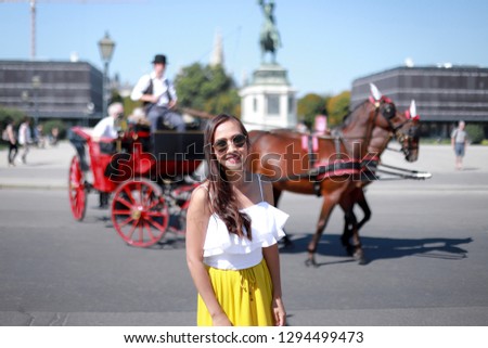 Happy asian tourist woman taking picture with horse carriage famous in Vienna city , Austria around Alte Hofburg Palace on a sunny day in the summer