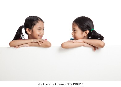 Happy Asian Twins Girls  Behind White Blank Banner On White Background