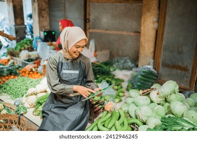 happy asian vegetable seller checking green groceries product using tablet - Powered by Shutterstock