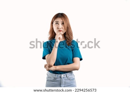 Happy Asian woman in blue t-shirt posing with hands and looking at camera on white background