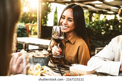Happy Asian Woman Drinking Red Wine Sitting At Restaurant Dining Table - Group Of Friends Having Bbq Dinner Party Outside - Food And Beverage Lifestyle Concept