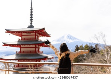 Happy Asian woman enjoy outdoor lifestyle travel at red Chureito Pagoda with Mt Fuji covered background in winter holiday vacation. People travel Japan landmark famous place and season change concept. - Shutterstock ID 2348069437