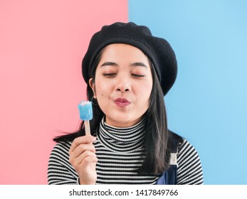 Happy Asian Woman Holding Blue Ice Cream Stick With Color Background.