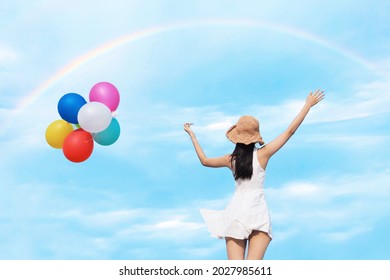 Happy Asian Woman Holding Colorful Of Balloons Over Blue Sky Background.