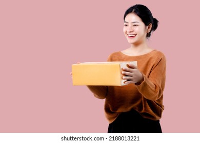 Happy Asian Woman Holding Parcel Box Isolated Over Pink Background.