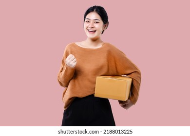 Happy Asian Woman Holding Parcel Box Isolated Over Pink Background.