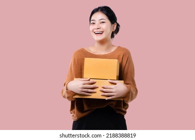 Happy Asian Woman Holding Parcel Box Isolated Over Pink Background.