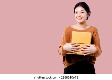 Happy Asian Woman Holding Parcel Box Isolated Over Pink Background.