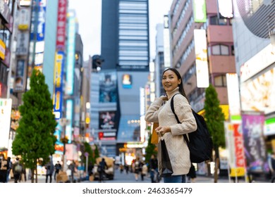 Happy Asian woman holding shopping bag walking at Shibuya district, Tokyo, Japan in evening. Attractive girl enjoy and fun outdoor lifestyle travel urban city street and shopping on holiday vacation. - Powered by Shutterstock