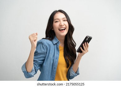 Happy Asian woman holding a smartphone and winning the prize. - Shutterstock ID 2175055125