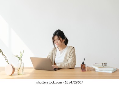 Happy Asian Woman At Home Using A A Laptop