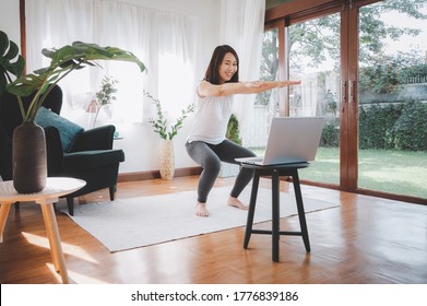 Happy Asian Woman Learned Online Workout Excercise Class At Home From Laptop. Self Isolation And Workout At Home During COVID-19