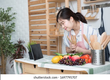 Happy Asian Woman Looking Recipe Tablet Kitchen Reading Cooking At Home,University Colleague Student Study Online With Social Media,Social Distancing, Stay At Home And Work From Home Concept.