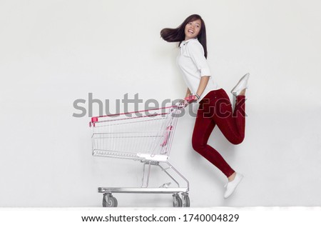 happy asian woman love shopping with trolley on white background.