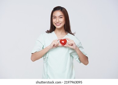 Happy Asian Woman Patient Showing Heart Isolated On White Background. Insurance Cardiovascular And Cardiac Concept.