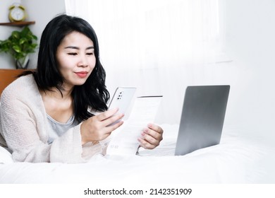 Happy Asian Woman Paying Bills Online From Home Hand Holding Smart Phone Scanning Qr Code 