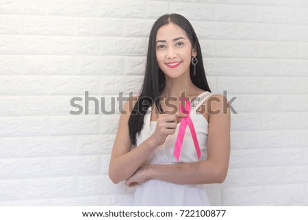 Happy Asian woman with pink ribbon for prevention breast cancer concept