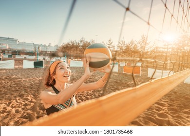 Happy Asian woman playing beach volleyball outdoors. Modern sports and fitness healthy lifestyle of youth people. Playing summer games