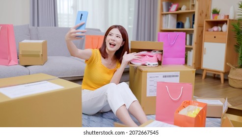 Happy Asian Woman Receive Packing Parcel After Online Shopping At Home And She Takes Selfie With New Shoes In Opening Delivery Box