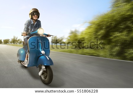 Happy asian woman riding scooter with high speed on the street