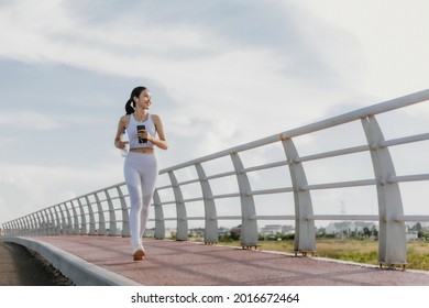 Happy Asian woman running outdoor in an urban area, healthy lifestyle, and sport concepts - Shutterstock ID 2016672464
