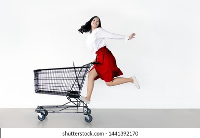happy asian woman with shopping cart ready for shopping on sale season - Beautiful casual shopper girl going to the store.