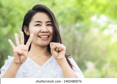 Happy Asian Woman Showing Finger Age 40 Years Old And Smiling To Camera In A Park 