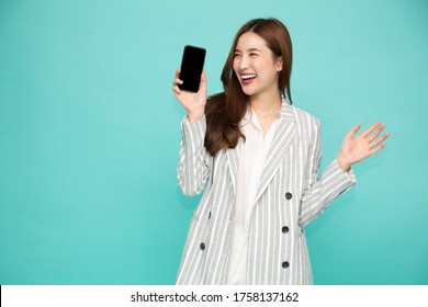 Happy Asian Woman Smile And Holding Mobile Phone Isolated Over Light Green Background