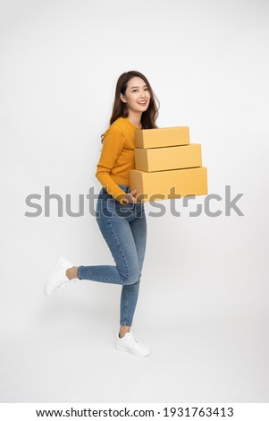 Happy Asian woman smiling and holding package parcel box isolated on white background, Delivery courier and shipping service concept, Full Length people composition