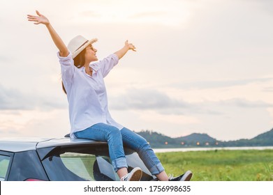 Happy Asian woman spread arms on car rooftop under sunset at seaside with nature  background during travel in holiday. Confidence cheerful girl with dawn sky. Sun sea and mountain. Vacation concept - Powered by Shutterstock