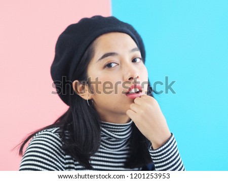 Happy Asian woman standing over pastel color background.