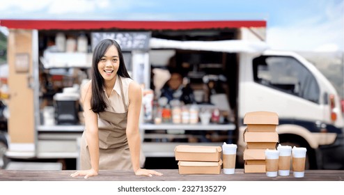 happy asian woman start new business food truck serving with box and cup for take away clients on blur food truck background - Powered by Shutterstock