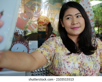 Happy Asian Woman Taking Selfie In Coffee Shop.