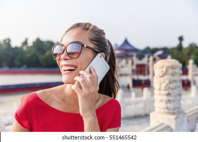 Happy Asian Woman Talking To Someone On The Phone. Girl Calling With Mobile App During China Summer Travel.