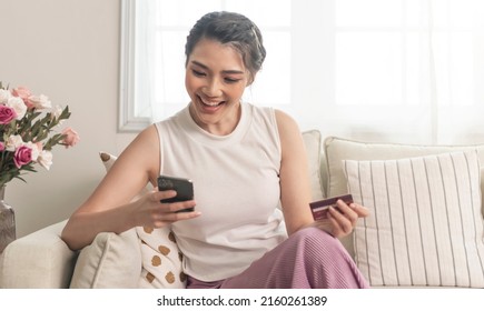 Happy Asian Woman Using Smartphone Shopping Online With Credit Card.  Lifestyle. Easy Pay Using Smart Phone Or Digital Device. 