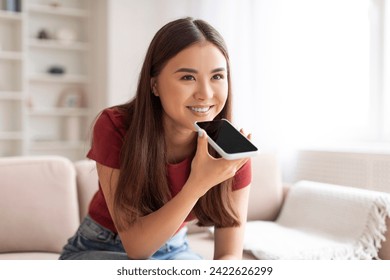 Happy Asian Woman Using Virtual Voice Assistant Option On Smartphone At Home, Smiling Korean Female Recording Audio Message On Mobile Phone, Enjoying Modern Technologies, Closeup Shot With Copy Space - Powered by Shutterstock