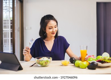 Happy Asian Woman Vegetarian Healthy Eating Salad Food And Use Tablet On The Table. Young Woman Vegetarian. Vegetables And Fruits. Vegan Food.