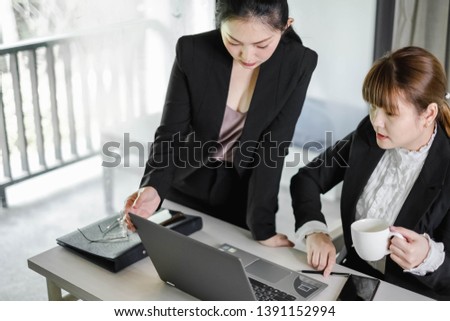 Happy Asian workingwomen working together at computer laptop. The successful businesswomen learning about e-commerce/e business as online technology is changing. Teamwork& collaboration concept.