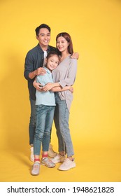 Happy Asian Young Family With One Child Standing Embracing And Smiling 