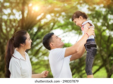 Happy Asian Young Family Spending Time Outdoor On A Summer Day