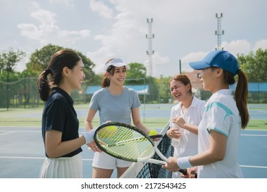 Happy asian young friendship talking and resting after match on the outdoor tennis court on a bright sunny day. Sport activity, tennis training and competition concept - Powered by Shutterstock