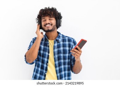 Happy Asian young man in casual clothes listening music with headphones, hold mobile phone - Shutterstock ID 2143219895