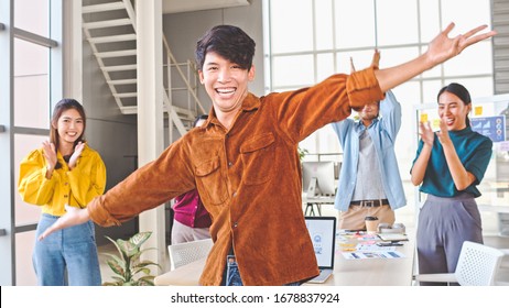 Happy Asian Young Man And Creative Colleague Coworker Woman, Dance And Clap Together In Modern Office. Workplace Party, Teamwork Group Celebration, Healthy Lifestyle, Positive Business People Concept