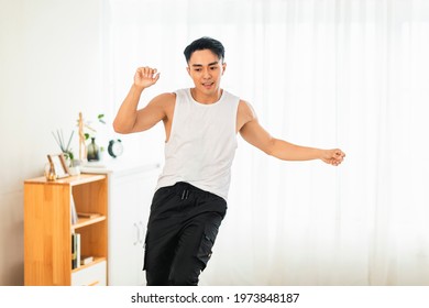 Happy Asian Young Man Doing Exercises And Dancing At Home