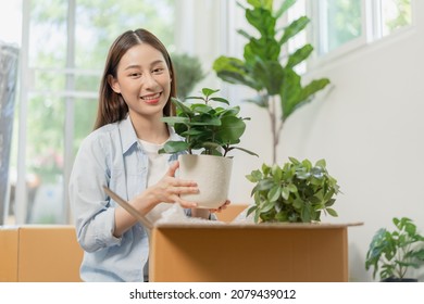 Happy Asian Young Woman, Customer Received, Unpack Package Carton Open Parcel In Cardboard Box, Holding Ceramic Plant Pot. Moving, Preparing In New House, Relocation. Online Shop Delivery At Home.