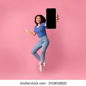 Happy Asian Young Woman Showing Empty Smartphone Screen While Jumping Up Over Pink Studio Background, Collage, Full Size Photo. Excited Lady Recommending Nice And Useful Mobile Application